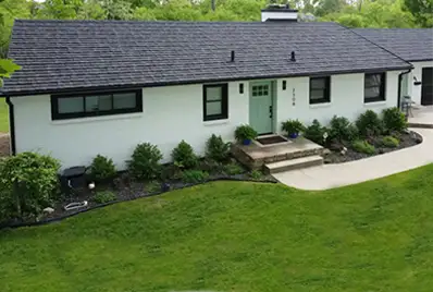 Off-White house with stone coated metal shingles.